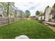 Spacious backyard with lush green grass, fenced-in privacy, and wood deck with multiple seating areas at 10688 Ashview Dr, Fishers, IN 46038