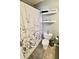Clean bathroom features a shower with decorative curtain, shelving, and functional toilet at 10688 Ashview Dr, Fishers, IN 46038