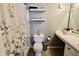 Bright bathroom featuring decorative shelves, a toilet, and a shower with a floral curtain at 10688 Ashview Dr, Fishers, IN 46038