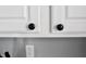 Close-up of modern black cabinet knobs on white kitchen cabinets, highlighting simple yet stylish design at 10688 Ashview Dr, Fishers, IN 46038