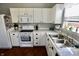 Bright kitchen features white cabinets, stainless steel sink, and ample counter space for cooking at 10688 Ashview Dr, Fishers, IN 46038