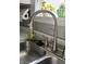 Modern stainless steel kitchen sink with silver fixtures and a view of plants on the window sill at 10688 Ashview Dr, Fishers, IN 46038
