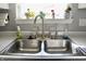 Stainless steel kitchen sink with a view of plants on the window sill above at 10688 Ashview Dr, Fishers, IN 46038