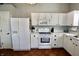 Well-lit kitchen features white cabinets, modern appliances, ample counter space and tile floors at 10688 Ashview Dr, Fishers, IN 46038