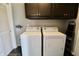 Functional laundry room featuring a washer, dryer, and dark cabinets for storage at 10688 Ashview Dr, Fishers, IN 46038