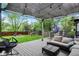 Inviting backyard featuring a shaded patio with furniture, a play area, and a green lawn at 10764 Gettysburg Pl, Carmel, IN 46032