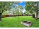 Spacious backyard featuring lush green lawn, mature trees, and a play area, perfect for outdoor activities at 10764 Gettysburg Pl, Carmel, IN 46032