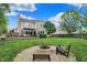 Large backyard featuring a stone fire pit, a patio, and a well-maintained green lawn at 10764 Gettysburg Pl, Carmel, IN 46032