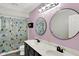 Modern bathroom featuring a double vanity with sleek fixtures and a shower with patterned curtain at 10764 Gettysburg Pl, Carmel, IN 46032
