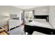 Cozy bedroom featuring wood floors, a large window, and a white dresser with a mirror at 10764 Gettysburg Pl, Carmel, IN 46032