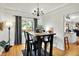 Dining area with sleek black furniture, hardwood floors, and modern decor adjacent to kitchen at 10764 Gettysburg Pl, Carmel, IN 46032