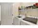 Functional laundry room with a modern washer and dryer, and ample storage space on shelves at 10764 Gettysburg Pl, Carmel, IN 46032