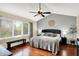 Bright main bedroom with a vaulted ceiling, ceiling fan, and large window with a bench for relaxing at 10764 Gettysburg Pl, Carmel, IN 46032