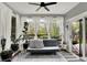 Cozy sunroom filled with light and plants, furnished with a sofa and a striped rug at 10764 Gettysburg Pl, Carmel, IN 46032