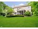 Well-maintained backyard with a covered patio and lush green lawn and manicured bushes at 11141 Saybrook Ct, Fishers, IN 46037