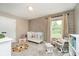 Cozy bedroom with wood accent wall, crib, and comfortable rocking chair by a window at 11141 Saybrook Ct, Fishers, IN 46037