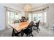 Sunlit dining room with a wooden table, black chairs, and large windows at 11141 Saybrook Ct, Fishers, IN 46037