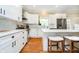 Spacious open-concept kitchen with white cabinets, a center island, stainless steel appliances, and wood floors at 11141 Saybrook Ct, Fishers, IN 46037