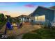 Backyard with a patio area, a fire pit, a built-in grill, a pergola, and green grass at sunset at 11438 Montoya Dr, Zionsville, IN 46077