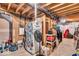 Unfinished basement with exposed ceiling, a refrigerator with stickers, a fan, and storage at 11438 Montoya Dr, Zionsville, IN 46077
