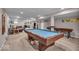 Finished basement features a billiard table, shuffleboard, comfortable seating and neutral decor at 11438 Montoya Dr, Zionsville, IN 46077
