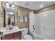 Bathroom with a single sink vanity, a toilet, and a shower/tub combination with white tile surround at 11438 Montoya Dr, Zionsville, IN 46077