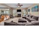 Cozy living room featuring a fireplace, large sectional sofa, and view into dining area at 11438 Montoya Dr, Zionsville, IN 46077