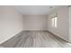 Empty bedroom featuring wood floors, neutral paint, and a window with a view of the neighborhood at 1151 Canterbury Ct # D, Indianapolis, IN 46260
