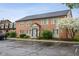 Two-story brick building with accessible parking featuring blooming tree and blue entryway at 1151 Canterbury Ct # D, Indianapolis, IN 46260