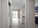 Hallway view of the light-filled apartment with gray wood floors and access to the kitchen and balcony at 1151 Canterbury Ct # D, Indianapolis, IN 46260