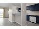 Open-concept kitchen featuring dark blue cabinets, updated countertops and appliances, and wood flooring at 1151 Canterbury Ct # D, Indianapolis, IN 46260
