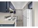 Well-lit galley kitchen features white appliances and dark cabinets, plus ample countertop space at 1151 Canterbury Ct # D, Indianapolis, IN 46260