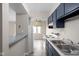 Bright eat-in kitchen features dark cabinets, a breakfast bar, stainless steel sink, and white appliances at 1151 Canterbury Ct # D, Indianapolis, IN 46260