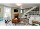 Cozy living room featuring a fireplace, built-in shelves under the stairs, and natural light from large windows at 116 High St, Brooklyn, IN 46111