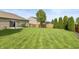 Large backyard featuring green lawn, wood fence, and professional landscaping at 131 Stamford Dr, Pittsboro, IN 46167