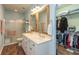 Bathroom featuring double sink vanity, shower with glass door, and a walk-in closet at 131 Stamford Dr, Pittsboro, IN 46167