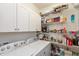 Functional laundry room featuring a washer and dryer, storage shelves, and white cabinets at 131 Stamford Dr, Pittsboro, IN 46167