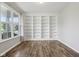 Bright, empty room featuring wood floors, large windows, and a built-in bookshelf at 16112 Lavina Ln, Fishers, IN 46040