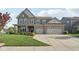 Charming two-story home with a brick and siding exterior, manicured lawn and an attached two-car garage at 16112 Lavina Ln, Fishers, IN 46040
