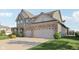 Exterior view showcasing a two-car garage and well-maintained lawn, and green and stone facade at 16112 Lavina Ln, Fishers, IN 46040