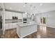 Modern kitchen featuring white cabinets, an island with seating, stainless steel appliances, and wood floors at 16112 Lavina Ln, Fishers, IN 46040