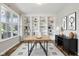 Bright home office featuring custom built-in shelving, hardwood floors, and a large window at 16112 Lavina Ln, Fishers, IN 46040