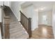 Carpeted staircase with wooden handrail leading to the upper level, next to the front door at 16112 Lavina Ln, Fishers, IN 46040