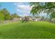 Large backyard with playset, green grass, and a wooden fence surrounding the area at 1633 E Thompson Rd, Indianapolis, IN 46227