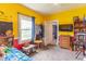 Colorful bedroom featuring bright yellow walls, ceiling fan, and ample natural light at 1633 E Thompson Rd, Indianapolis, IN 46227