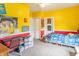Inviting bedroom featuring bright yellow walls, a ceiling fan, and comfortable furniture at 1633 E Thompson Rd, Indianapolis, IN 46227