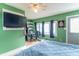 Comfortable bedroom with mounted television, green walls, and plenty of natural light at 1633 E Thompson Rd, Indianapolis, IN 46227