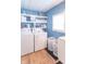 Laundry room with washer, dryer, shelving, wood-look flooring and window at 1633 E Thompson Rd, Indianapolis, IN 46227