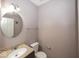 Half bath features a granite vanity with silver faucet and a framed, circular mirror at 2006 Creek Bank Dr, Columbus, IN 47201