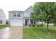 Charming two-story home with an attached garage and well-maintained lawn at 2006 Creek Bank Dr, Columbus, IN 47201